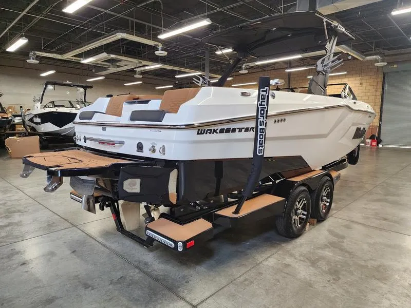 Slide: The Image of 2025 Malibu 24 MXZ boat on trailer in showroom, featuring sleek design and modern features. - 5