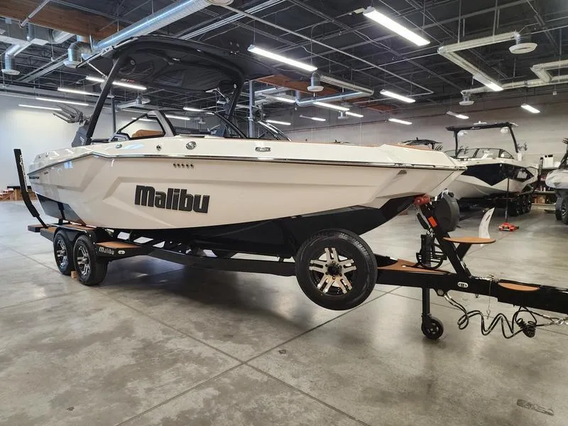 Slide: The Image of 2025 Malibu 24 MXZ boat on trailer in showroom, sleek design, modern features. - 6