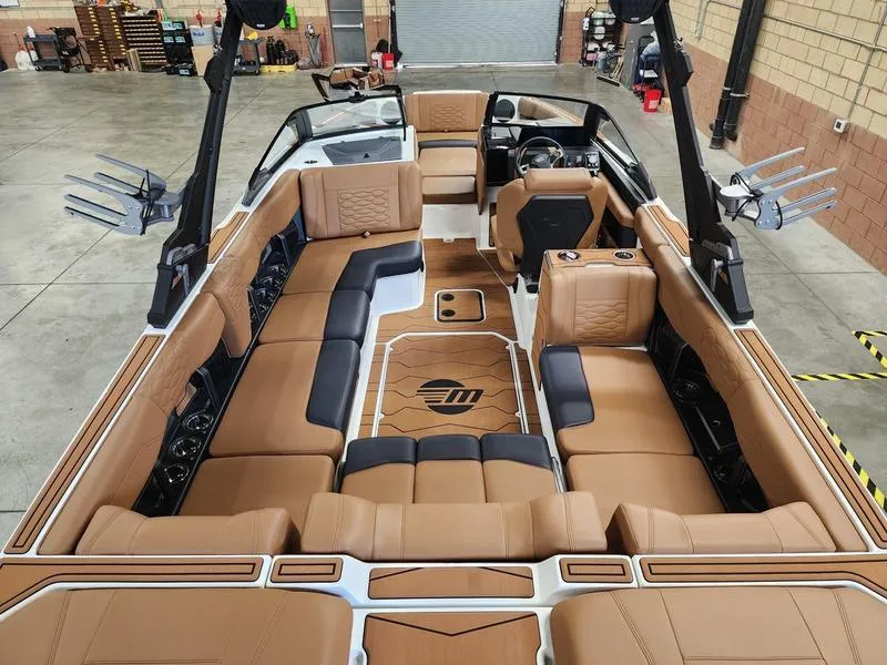 Slide: The Image of 2025 Malibu 24 MXZ boat interior with luxurious tan seating and modern design. - 9