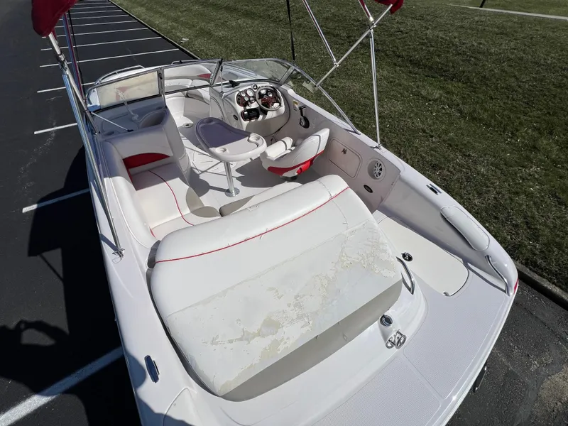 Slide: The Image of 2006 Tahoe 204 WT boat with white interior, parked on asphalt near grass. - 11