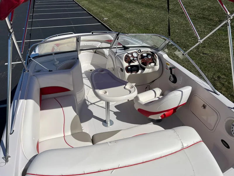 Slide: The Image of 2006 Tahoe 204 WT boat interior with white and red seating, steering console, and table. - 12