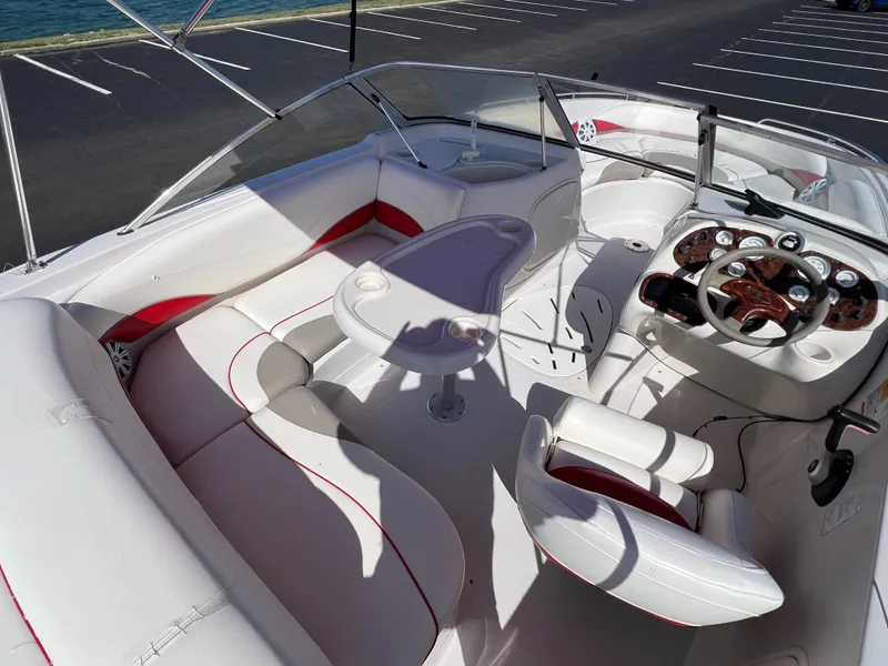 Slide: The Image of 2006 Tahoe 204 WT boat interior with white and red seating, steering console, and table. - 13