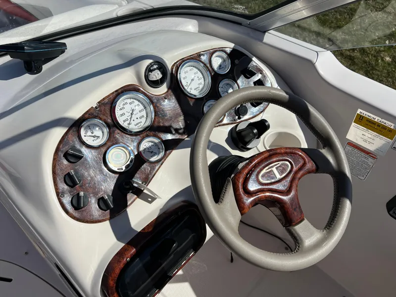 Slide: The Image of 2006 Tahoe 204 WT boat dashboard with gauges and steering wheel. - 17