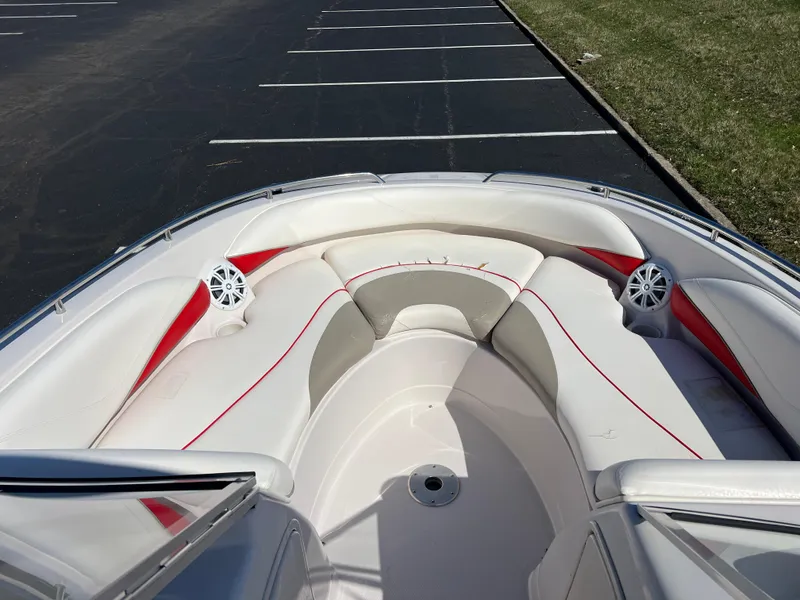 Slide: The Image of 2006 Tahoe 204 WT boat interior with white and red seating in a parking lot. - 18