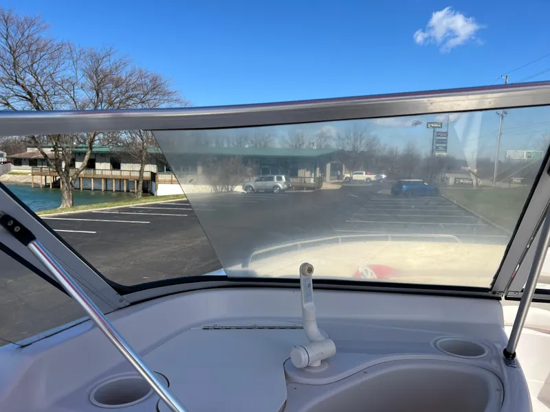 Slide: The Image of 2006 Tahoe 204 WT boat windshield view with clear sky and parking lot. - 27