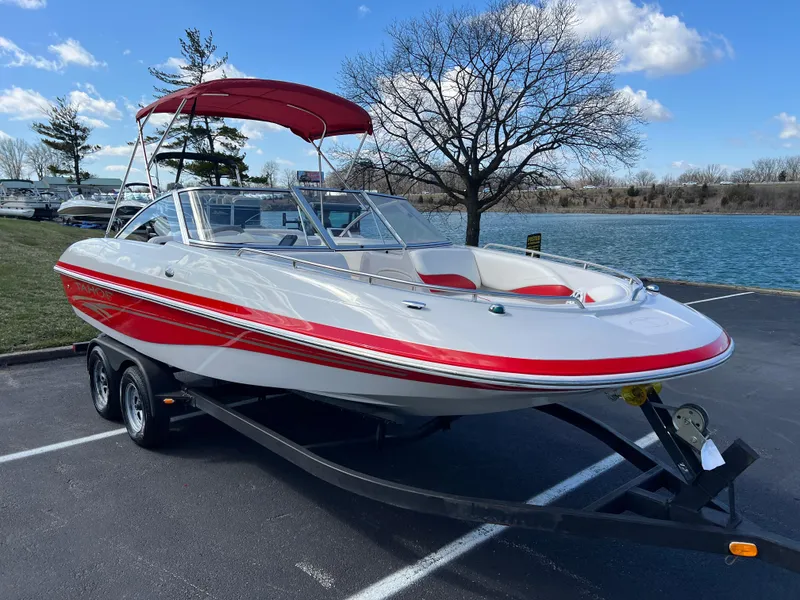 Slide: The Image of 2006 Tahoe 204 WT boat with red accents on a trailer by a lake. - 3