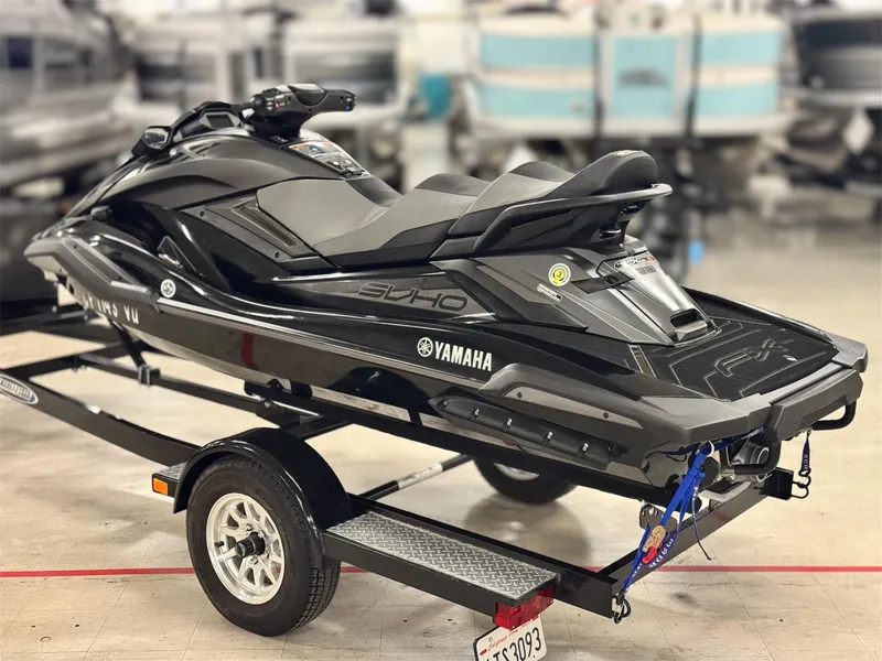 Slide: The Image of 2021 Yamaha WaveRunner FX Cruiser SVHO on trailer, sleek black design in showroom setting. - 5