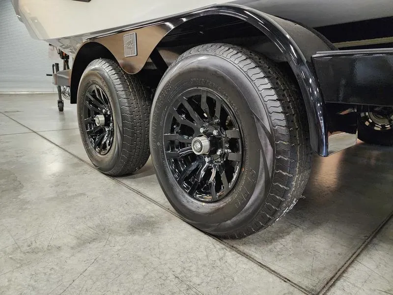 Slide: The Image of 2025 Axis T235 trailer with black alloy wheels on a concrete floor. - 24