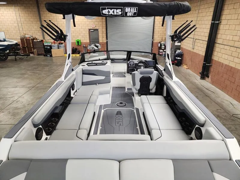 Slide: The Image of 2025 Axis T235 boat interior with spacious seating and modern design in a warehouse setting. - 8