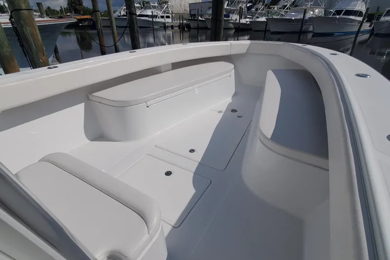 Slide: The Image of 2014 Bahama 41 FS boat interior with seating and storage, docked at marina. - 11