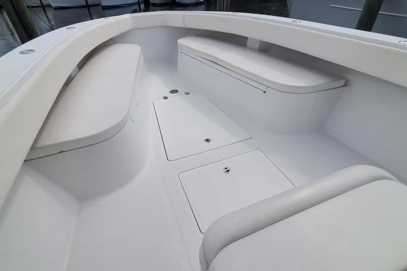Slide: The Image of 2014 Bahama 41 FS boat interior with white seating and storage compartments. - 15