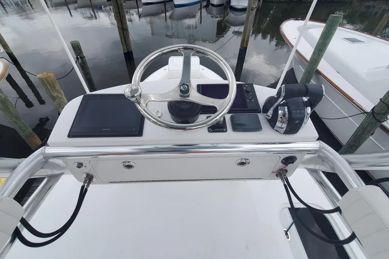 Slide: The Image of 2014 Bahama 41 FS boat helm with steering wheel and controls at dock. - 19