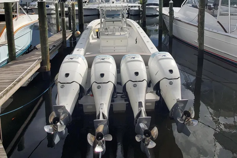 Slide: The Image of 2014 Bahama 41 FS boat with four powerful outboard engines docked at a marina. - 24