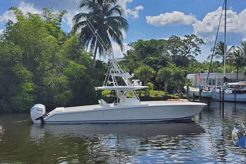 Slide: The Image of 2014 Bahama 41 FS boat docked on a sunny day with lush greenery. - 26