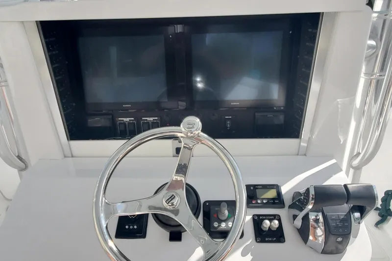 Slide: The Image of Control panel of 2014 Bahama 41 FS boat with steering wheel and navigation screens. - 5