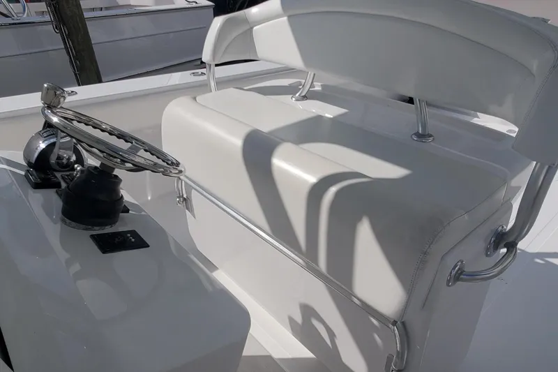 Slide: The Image of 2014 Bahama 41 FS boat helm with white cushioned seating and steering wheel. - 6