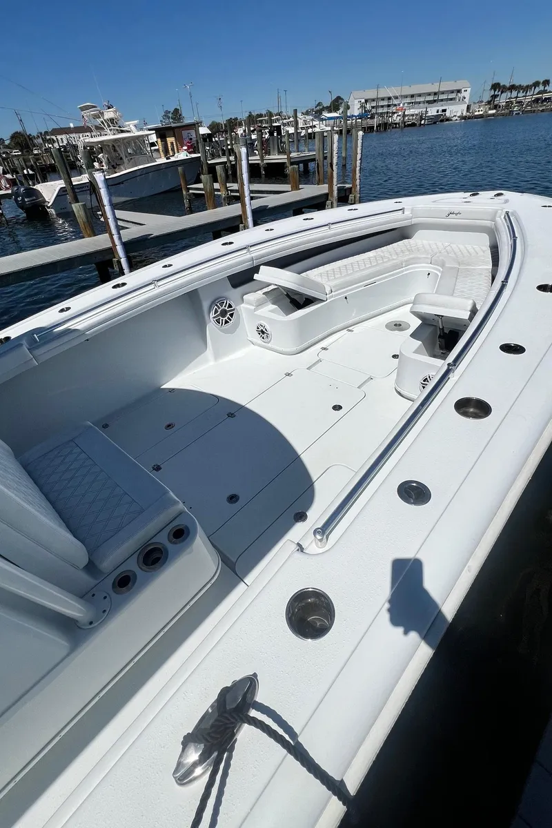 Slide: The Image of 2021 Yellowfin 36 Offshore boat docked, showcasing spacious deck and seating area. - 19