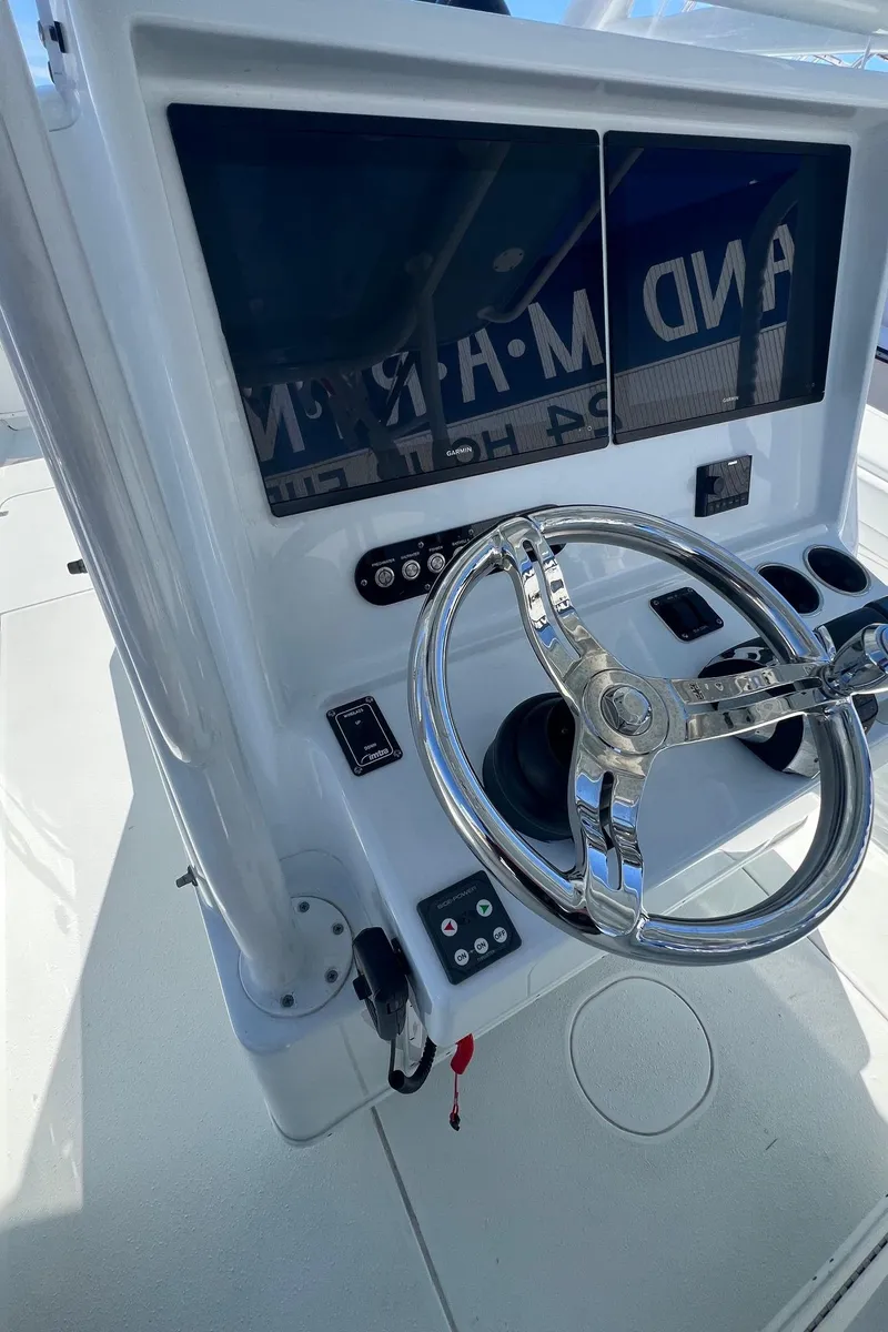 Slide: The Image of 2021 Yellowfin 36 Offshore boat helm with chrome steering wheel and control panel. - 22
