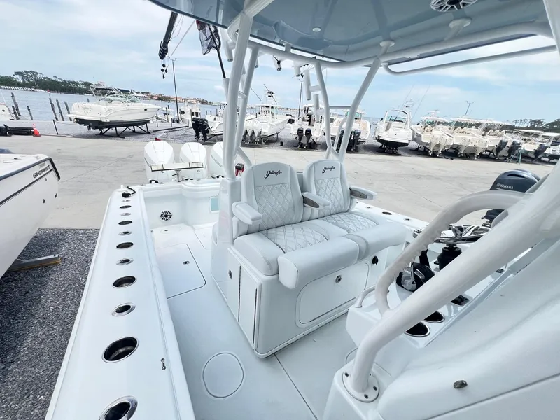 Slide: The Image of 2021 Yellowfin 36 Offshore boat interior with seating and control console at a marina. - 36