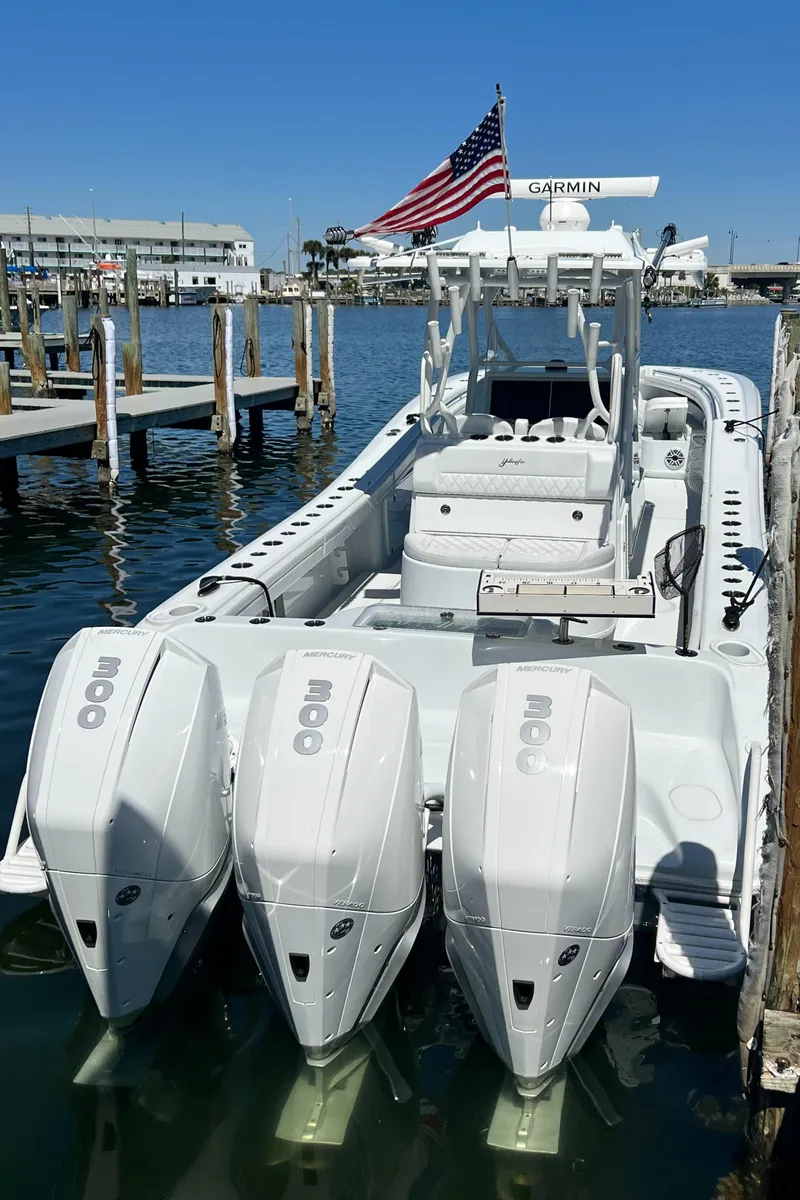 Slide: The Image of 2021 Yellowfin 36 Offshore boat with triple engines docked, American flag visible. - 5