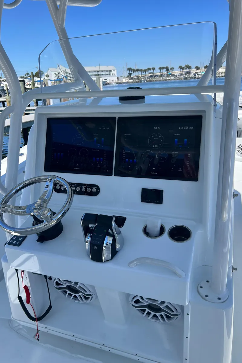 Slide: The Image of 2021 Yellowfin 36 Offshore boat console with dual screens and steering wheel, docked at marina. - 7
