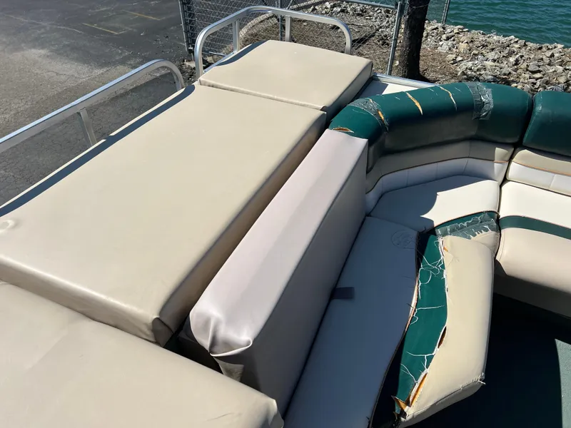 Slide: The Image of 1998 Fisher Freedom 200 DLX pontoon boat with worn seating and visible upholstery damage. - 16