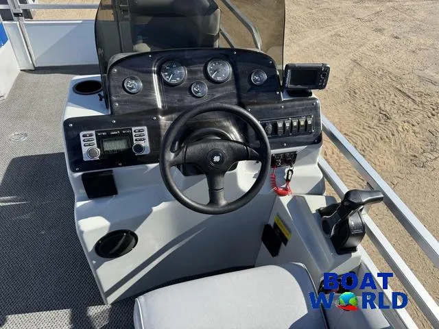 Slide: The Image of 2011 TMC 2200 SE Pontoon boat dashboard with steering wheel and control panel. - 20