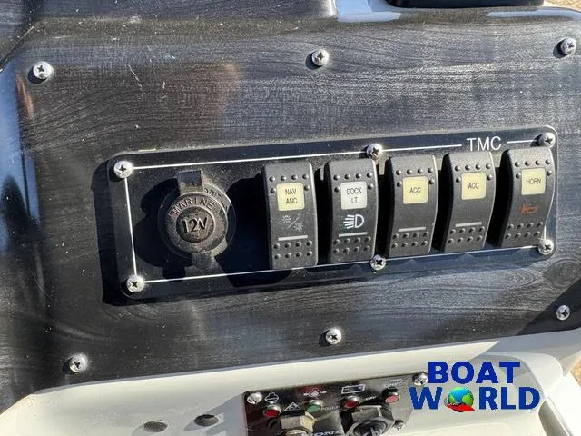 Slide: The Image of 2011 TMC 2200 SE Pontoon dashboard with switches and 12V outlet, Boat World logo visible. - 24