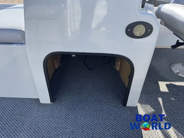 Slide: The Image of 2011 TMC 2200 SE Pontoon storage compartment with gray carpet and Boat World logo. - 29