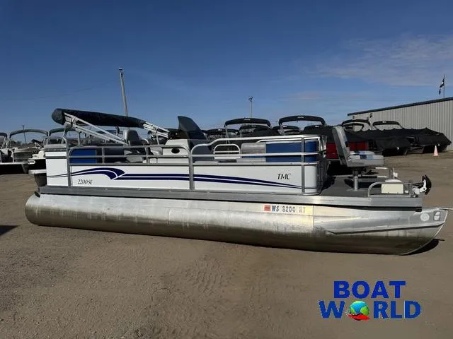 Slide: The Image of 2011 TMC 2200 SE Pontoon boat at Boat World dealership, parked on gravel. - 48