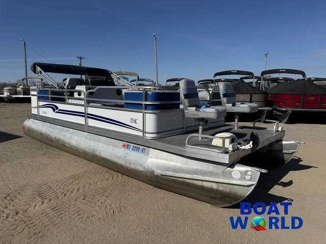 Slide: The Image of 2011 TMC 2200 SE Pontoon boat in a dealership lot, featuring dual seating and aluminum pontoons. - 49