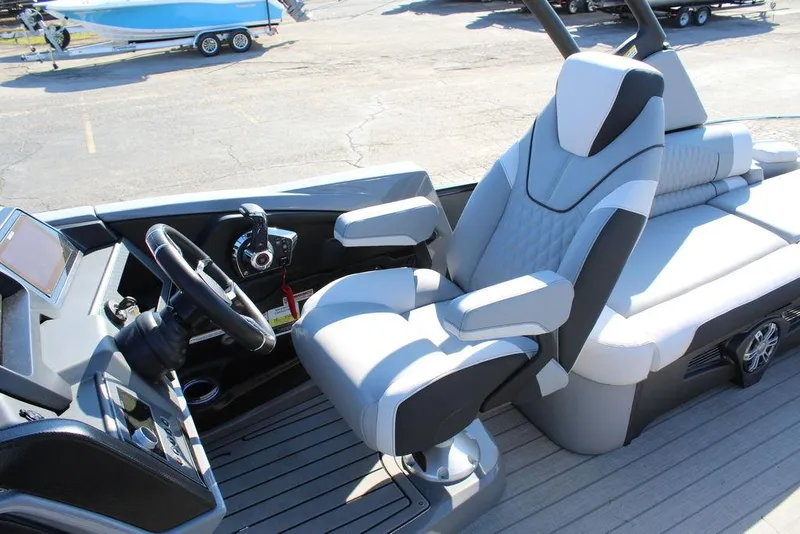 Slide: The Image of 2025 Avalon Excalibur LTD Quad Lounge 25 FT boat interior with modern seating and steering. - 21