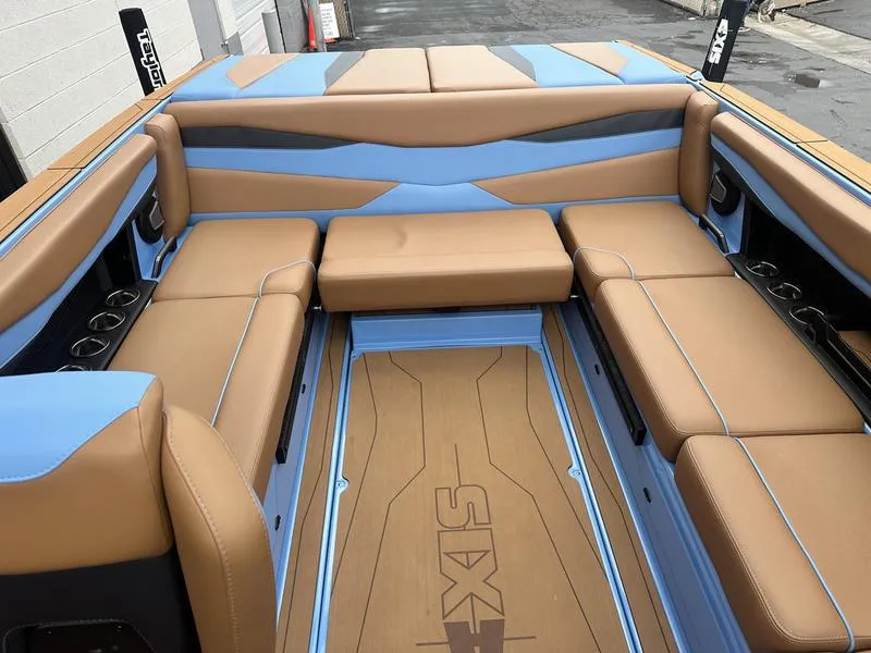 Slide: The Image of 2024 Axis A225 boat interior with tan and blue seating, featuring ample space and cup holders. - 10