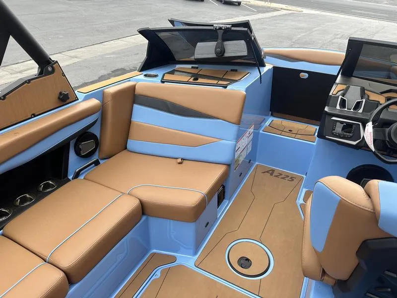 Slide: The Image of 2024 Axis A225 boat interior with tan and blue seating, modern dashboard, and spacious layout. - 14