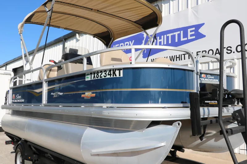 Slide: The Image of 2023 Sun Tracker Bass Buggy 18 DLX pontoon boat with canopy, displayed outdoors. - 10