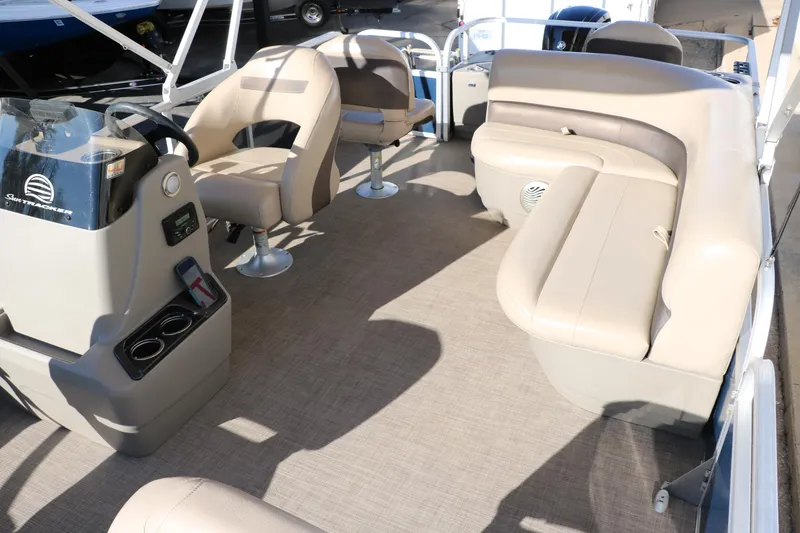 Slide: The Image of 2023 Sun Tracker Bass Buggy 18 DLX interior with beige seating and steering console. - 16