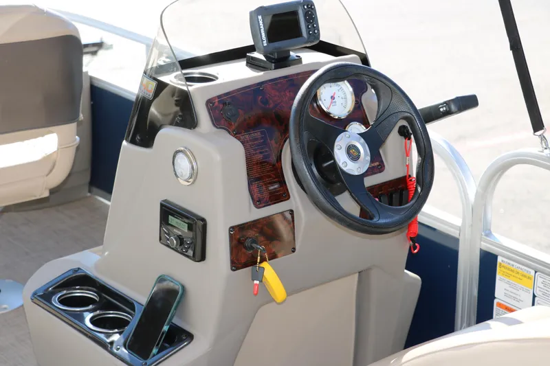 Slide: The Image of 2023 Sun Tracker Bass Buggy 18 DLX boat console with steering wheel and navigation equipment. - 23