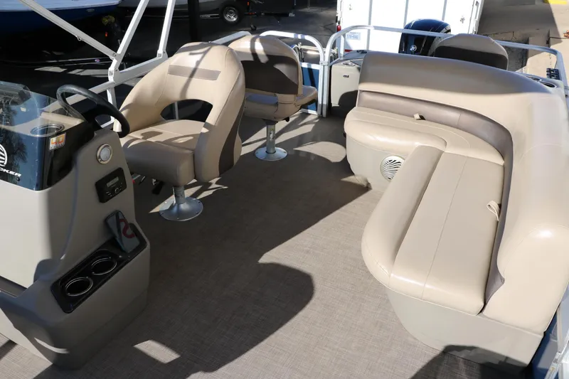 Slide: The Image of 2023 Sun Tracker Bass Buggy 18 DLX pontoon boat interior with beige seating and steering console. - 24