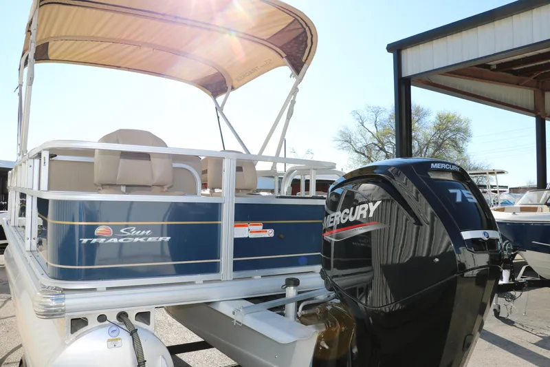 Slide: The Image of 2023 Sun Tracker Bass Buggy 18 DLX pontoon boat with Mercury 75 engine, under a canopy. - 5