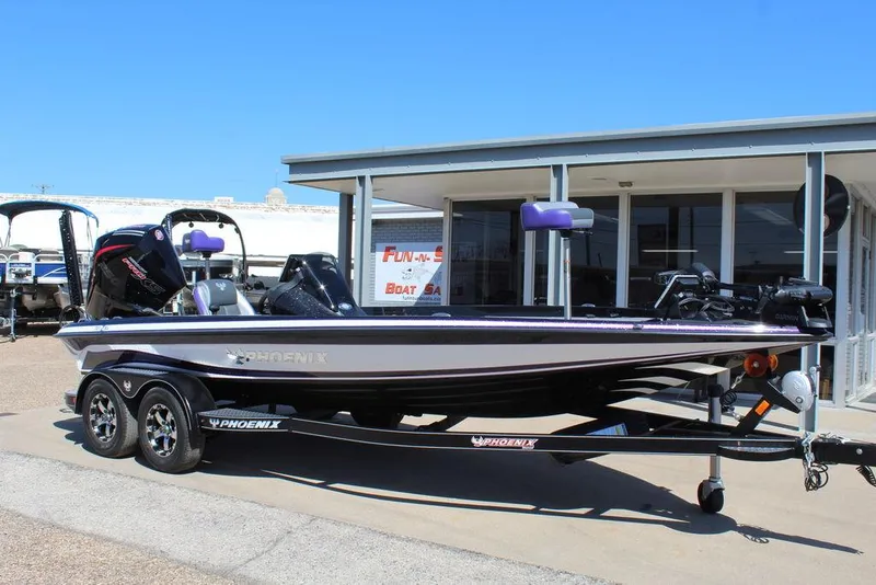 Slide: The Image of 2025 Phoenix 721 ZXL boat on trailer, parked outside a building under clear blue sky. - 1