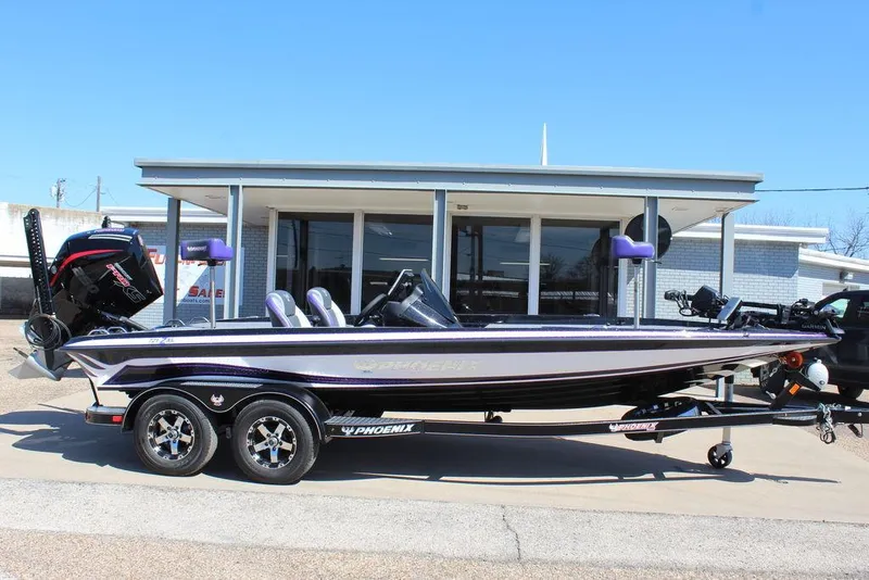Slide: The Image of 2025 Phoenix 721 ZXL bass boat parked outside a building. - 2