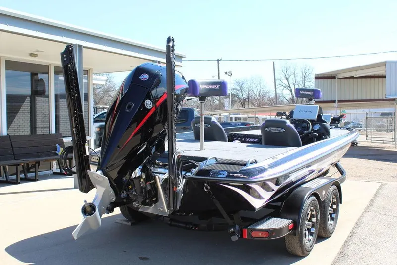 Slide: The Image of 2025 Phoenix 721 ZXL boat with dual motors and trailer parked outdoors. - 5