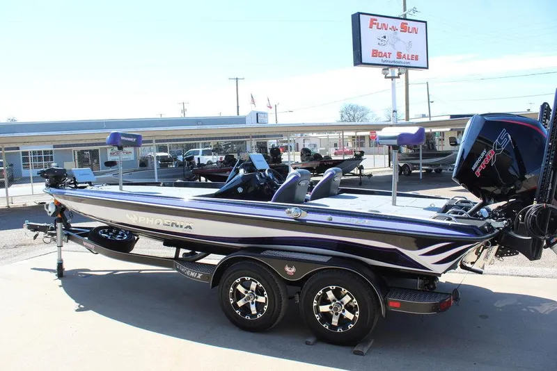 Slide: The Image of 2025 Phoenix 721 ZXL boat at dealership, side view with trailer and outboard motor. - 6