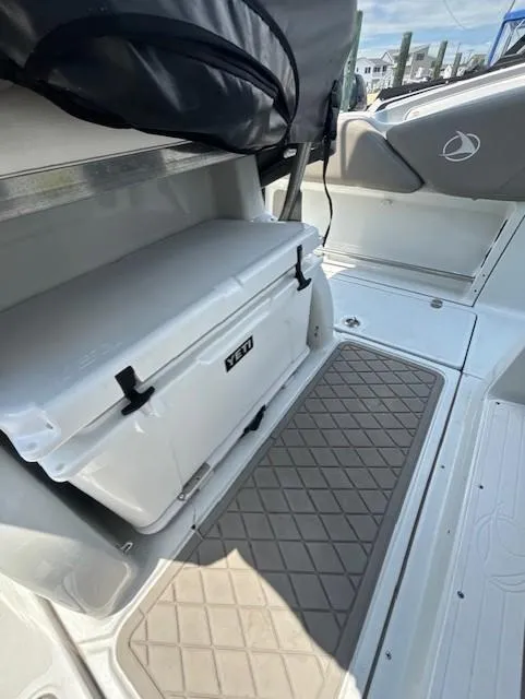Slide: The Image of 2022 Finseeker 230 CC boat interior with storage and cooler. - 11