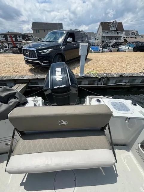 Slide: The Image of 2022 Finseeker 230 CC boat with Yamaha outboard motor, docked near a black SUV. - 13