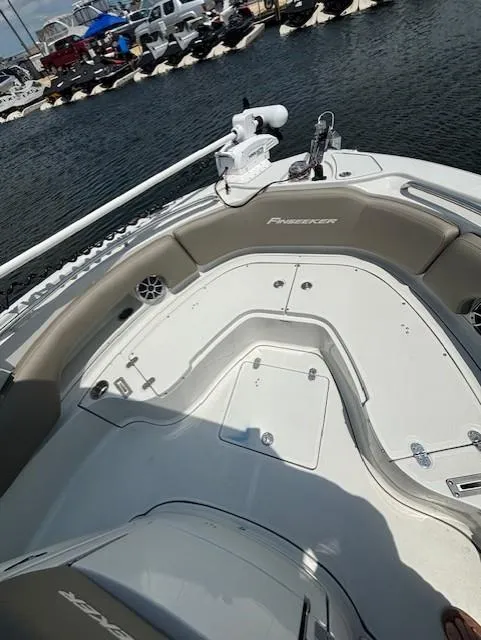 Slide: The Image of 2022 Finseeker 230 CC boat interior, featuring spacious seating and modern design at a marina. - 16