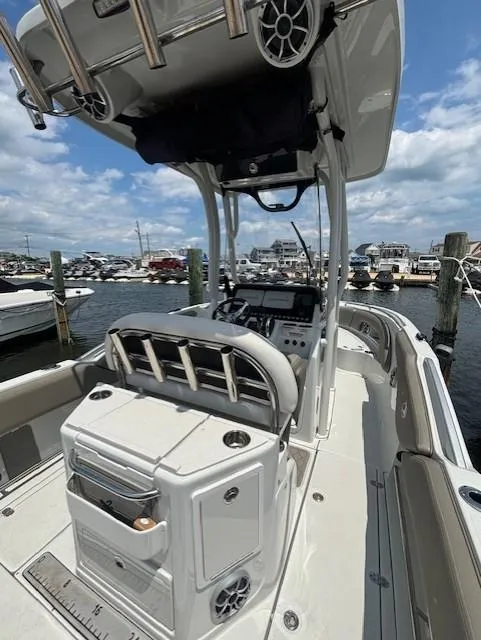 Slide: The Image of 2022 Finseeker 230 CC boat interior at marina, showcasing helm and seating. - 17