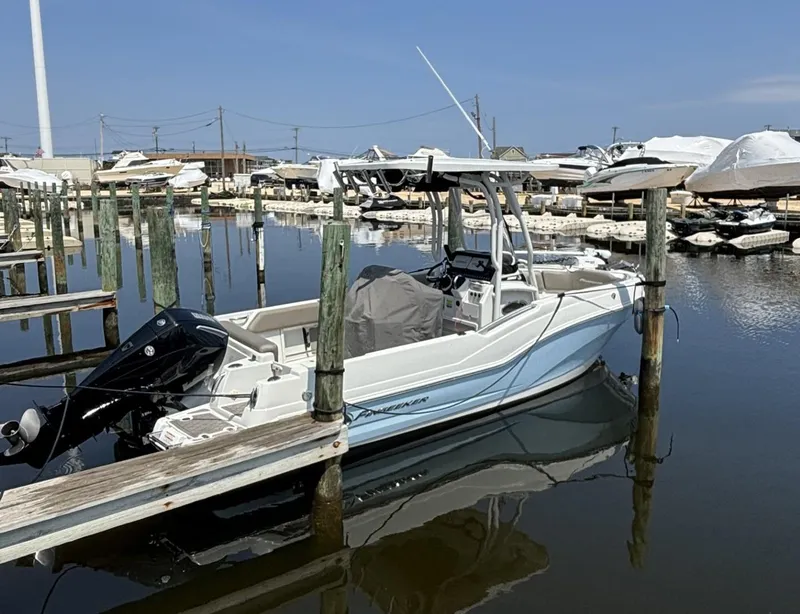 Slide: The Image of 2022 Finseeker 230 CC boat docked in a marina under clear skies. - 3