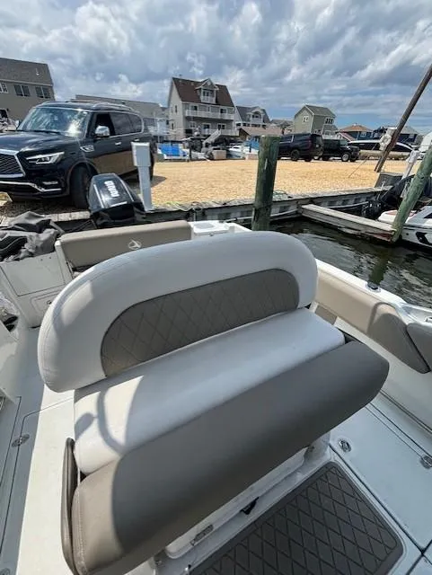 Slide: The Image of 2022 Finseeker 230 CC boat interior with dockside view and coastal homes. - 8