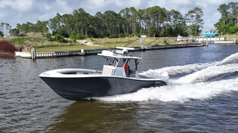 Slide: The Image of 2022 Yellowfin 34 boat cruising on a river with lush greenery in the background. - 10